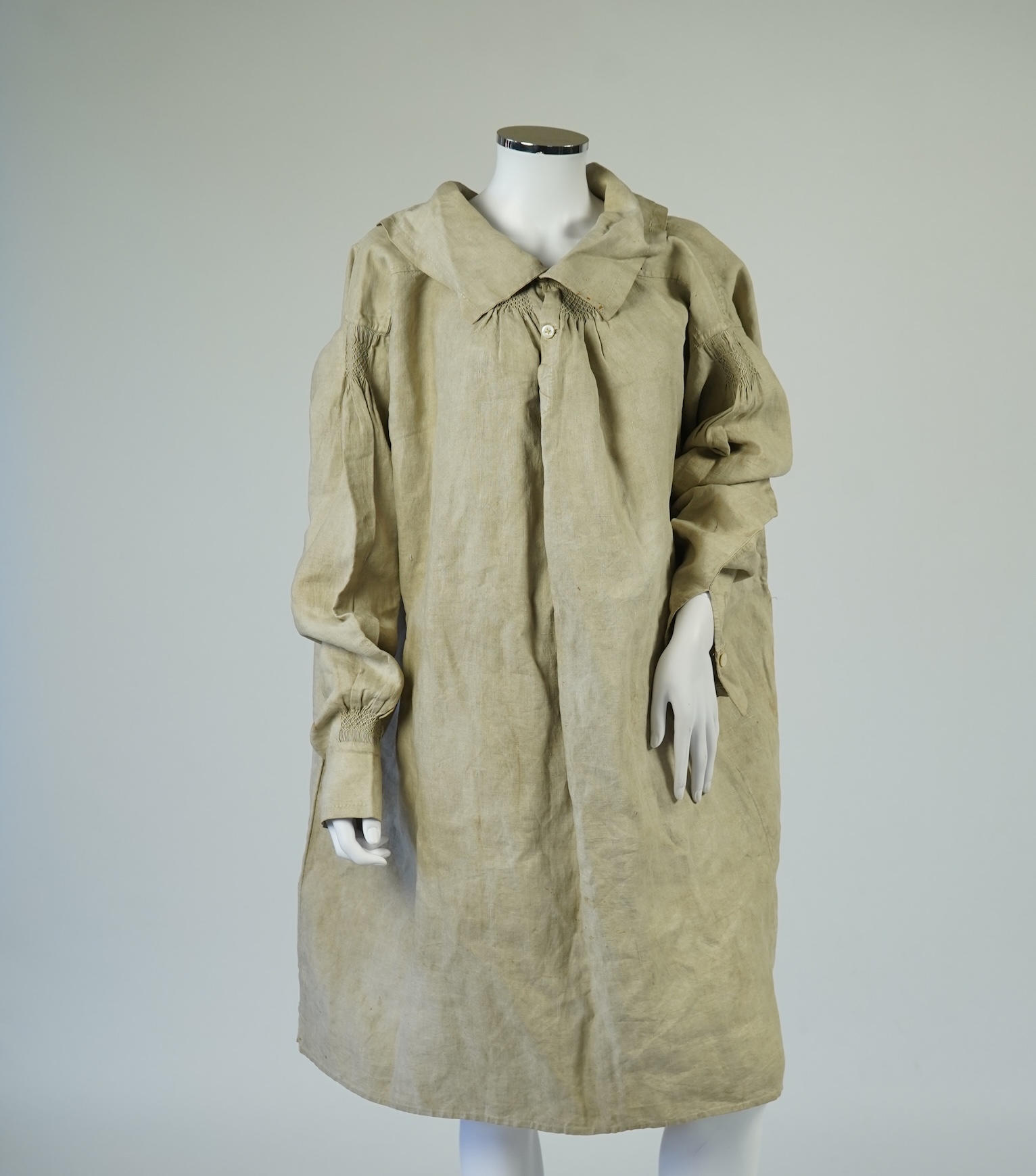A 19th century heavy linen Shepherd’s smock, with small smocked shoulders and front and back neck panels under collar., 97cm long. Condition - patched and small darn near top and minor wear, usual for age and use.